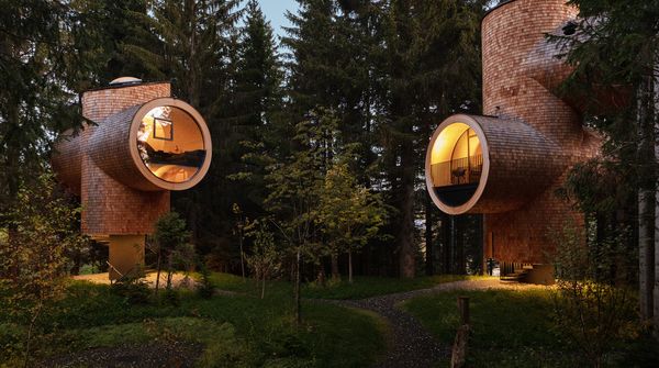 Futuristische Hotelgebäude mitten im Wald bei Dämmerung